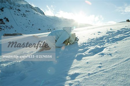 Teen girl curled up in snow