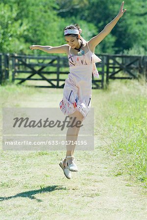 Young woman jumping in rural setting