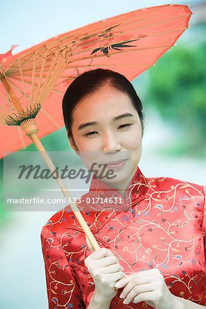 Young woman wearing traditional Chinese clothing, holding parasol, portrait