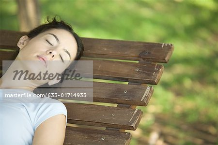 Woman sleeping on bench, cropped