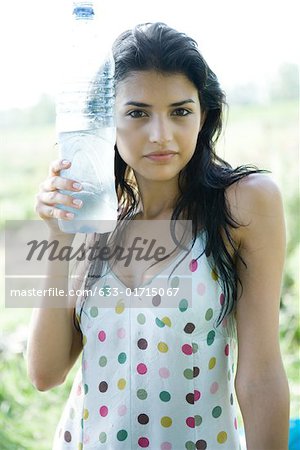 https://image1.masterfile.com/getImage/633-01715067em-young-woman-holding-cold-bottle-of-water-up-to.jpg