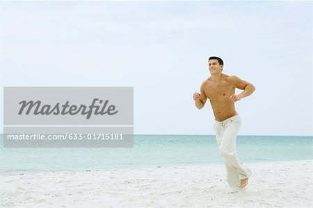 Man running on beach, full length