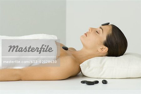 Woman undergoing lastone therapy, eyes closed