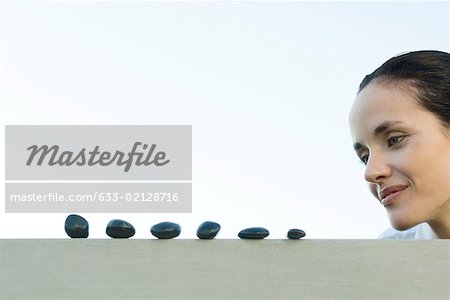 Woman looking at line of pebbles