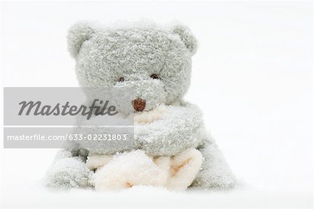 Teddy bear holding blanket covered in imitation snow Stock Photo