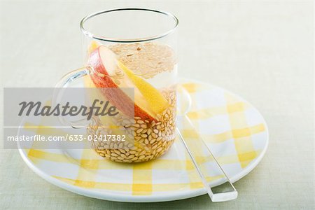 Sesame seeds floating in glass mug with slices of lemon and apple