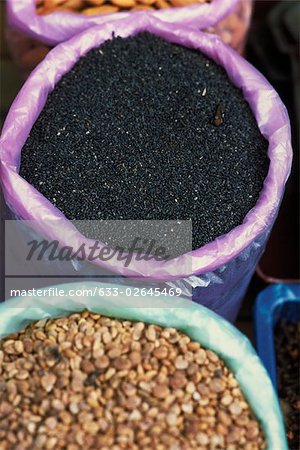 Nigella seeds and lentils in buckets, high angle view