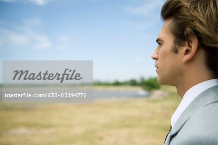 Man at lake shore contemplatively looking at view