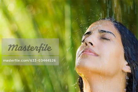 Young woman under falling water, portrait