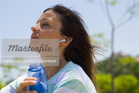 Woman listening to earphones outdoors