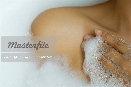Woman taking bubble bath, cropped