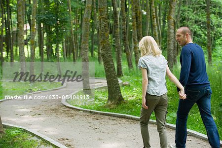 Couple walking on path in woods