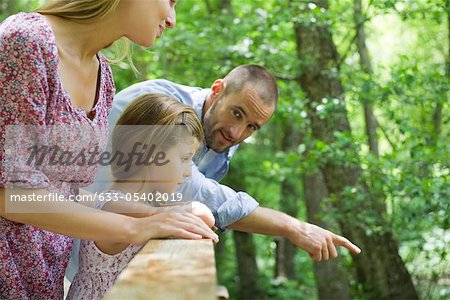 Family outdoors together, looking over railing