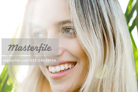 Young woman smiling in thought outdoors