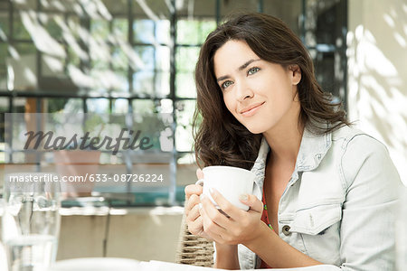 Young woman enjoying cup of coffee outdoors