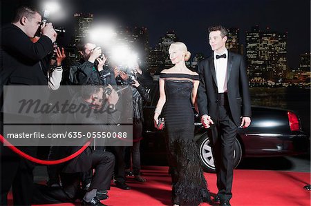 Celebrities Posing For Paparazzi On Red Carpet Stock Photo