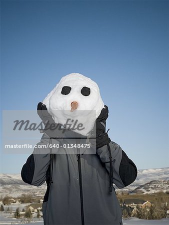 Close-up of a man holding a snowman head