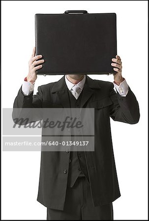 Businessman holding a briefcase in front of his face