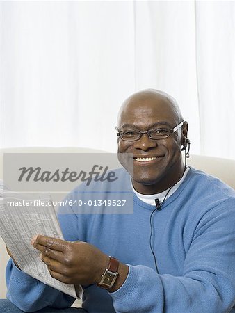 Portrait of a senior man holding a newspaper and smiling