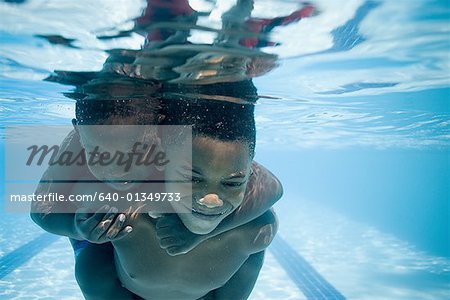 Boys swimming underwater in pool