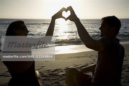 Youve Taught Me The True Meaning Of Love. A Couple Forming A Heart Shape  With Their Hands While Sitting On The Beach. Stock Photo, Picture and  Royalty Free Image. Image 198911221.