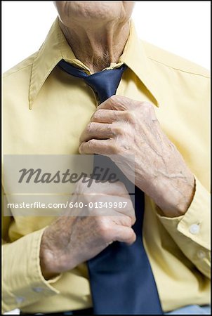 Mid section view of a senior man getting dressed