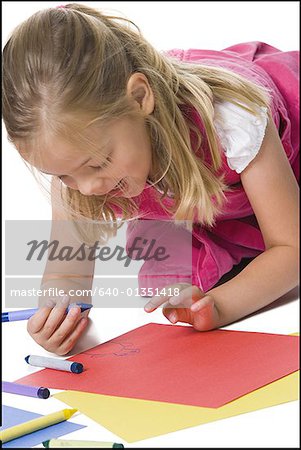Close-up of a girl drawing on a sheet of paper