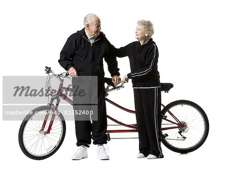 Older couple riding a tandem bicycle
