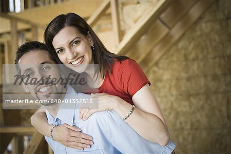 Portrait of a young woman embracing a young man from behind