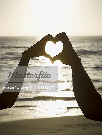 Youve Taught Me The True Meaning Of Love. A Couple Forming A Heart Shape  With Their Hands While Sitting On The Beach. Stock Photo, Picture and  Royalty Free Image. Image 198911221.