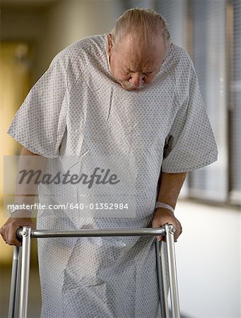 Male patient walking with a walker in a corridor