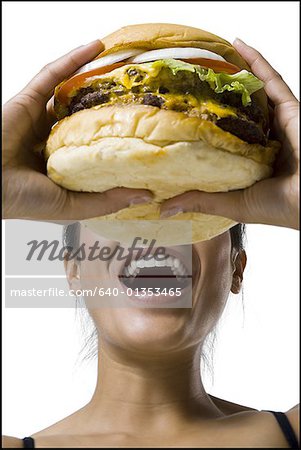 Woman eating a supersized hamburger