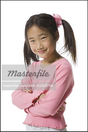 Portrait of a girl standing with her arms folded and smiling