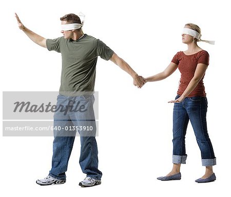 Blindfolded young man leading to a blindfolded young woman
