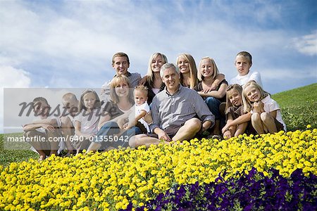 Large family group on hill with happy face floral display