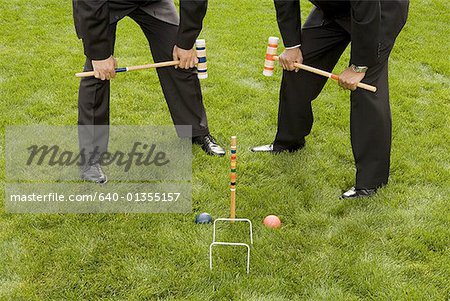 Two businessmen playing croquet