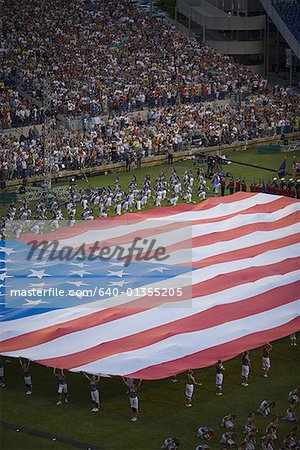 High angle view of a group of people holding a large American Flag