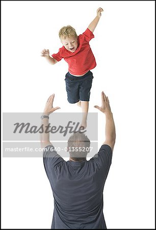 Rear view of a father catching his son