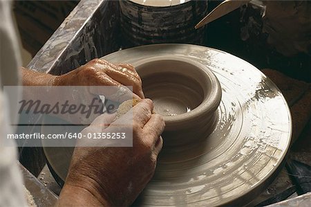 Male hands with pottery wheel and sponge