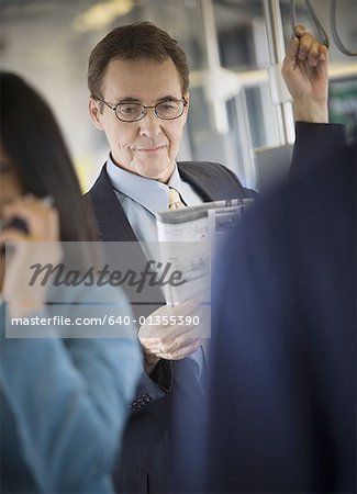 Businessman reading a newspaper on a commuter train Businessman reading a newspaper on a commuter train