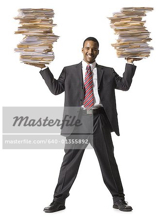 Man holding stacks of paperwork smiling