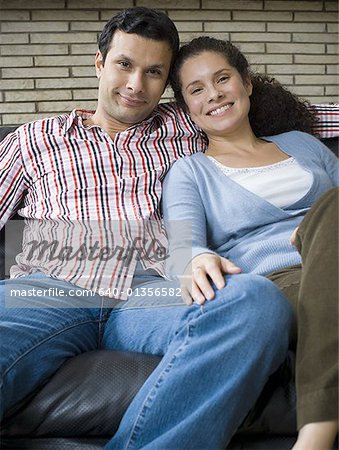 Portrait of a couple sitting on a couch and smiling