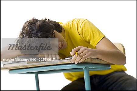 Close Up Of A Teenage Boy Sleeping On A Desk Stock Photo