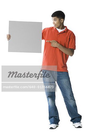 Young man pointing towards a blank sign