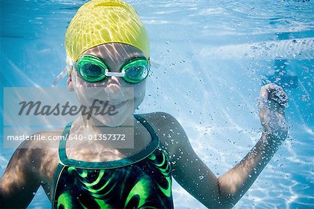 Girl swimming underwater in pool