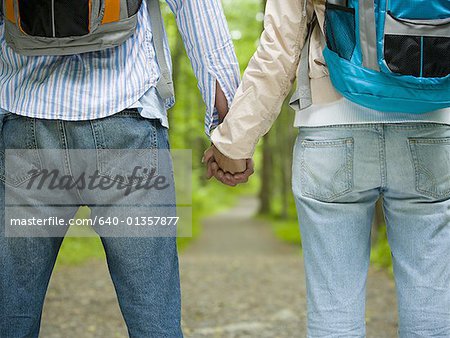 Mid section view of a young couple holding hands and standing