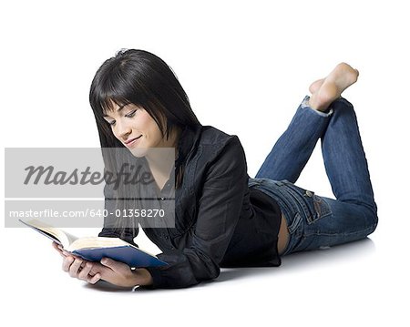A Woman in Denim Clothes Reading a Book Outdoors · Free Stock Photo