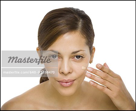 Portrait of a woman applying liquid makeup