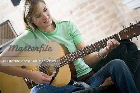 Teenage girl playing the guitar