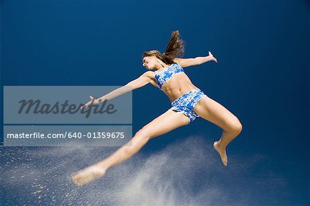 Low angle view of a young woman jumping